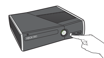 Указательный палец нажимает кнопку подключения в нижней правой части передней поверхности консоли Xbox 360 S.
